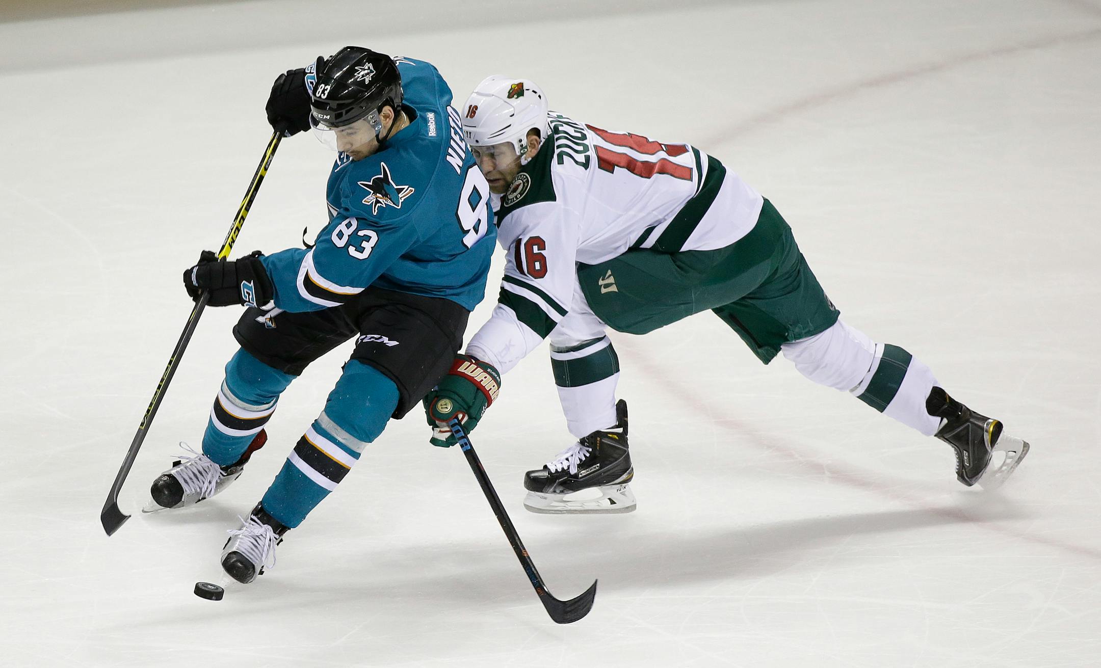 San Jose Sharks left wing Matt Nieto, left, and Minnesota Wild left wing Jason Zucker, right, battle for the puck in the first period of an NHL hockey game Saturday, Jan. 23, 2016, in San Jose, Calif. (AP Photo/Eric Risberg)