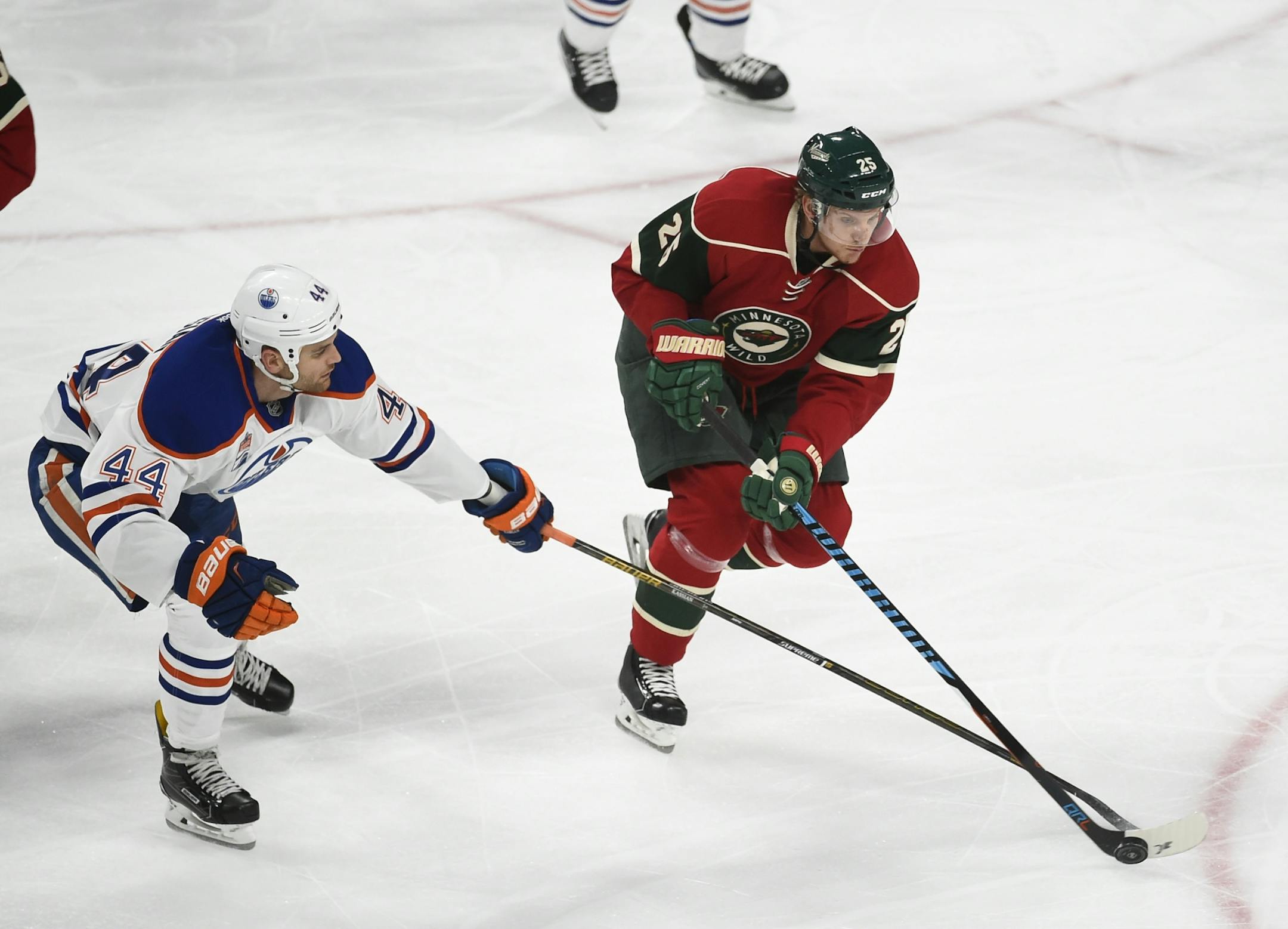 Edmonton Oilers' center Tyler Graovac, left, and Minnesota Wild defenseman Jonas Brodin battle for control of the puck during the first period of an NHL hockey game, Friday, Dec. 9, 2016, in St. Paul, Minn.