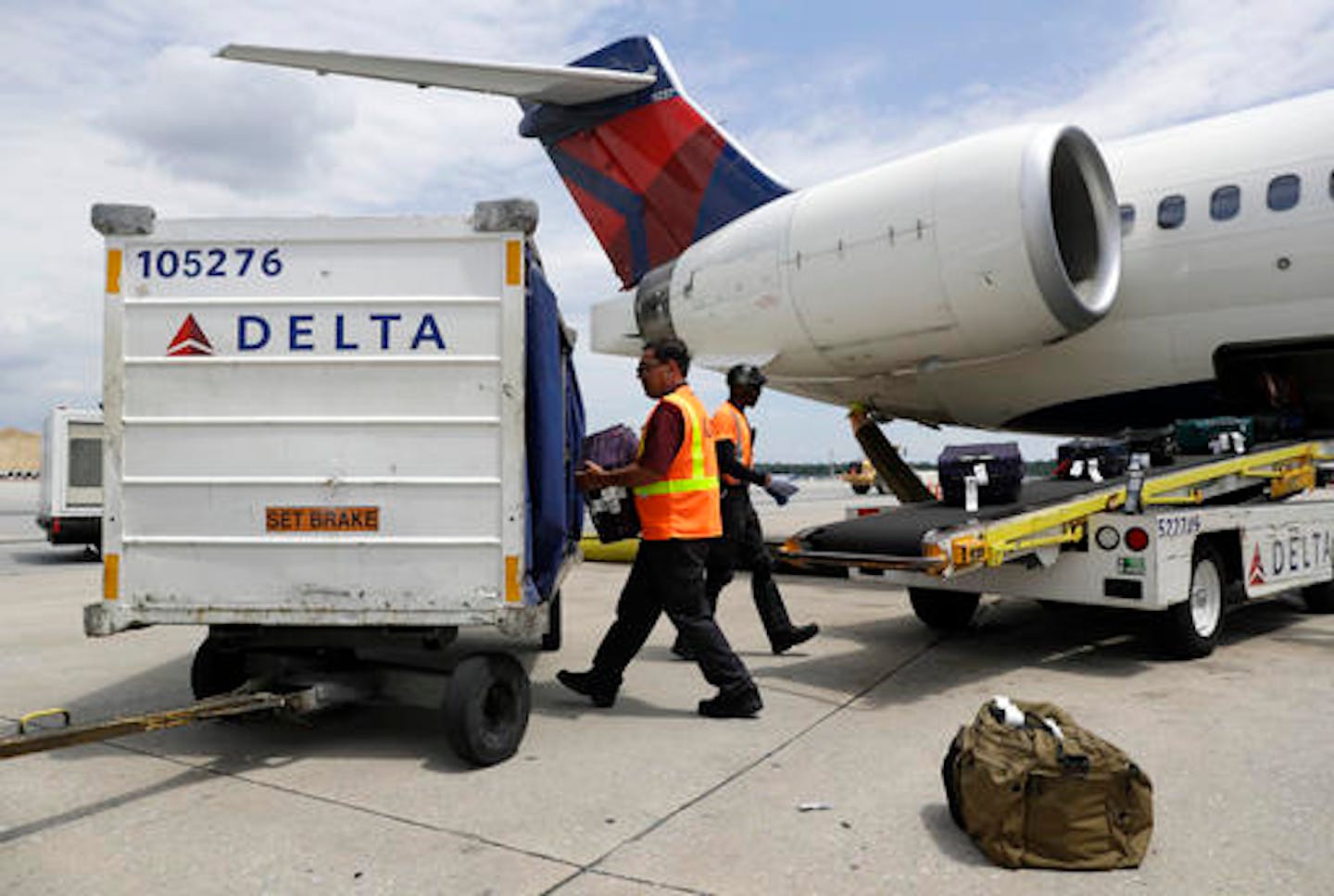 Workers unload baggage from a Delta Air Lines flight at Baltimore-Washington International Thurgood Marshall Airport in Linthicum, Md.