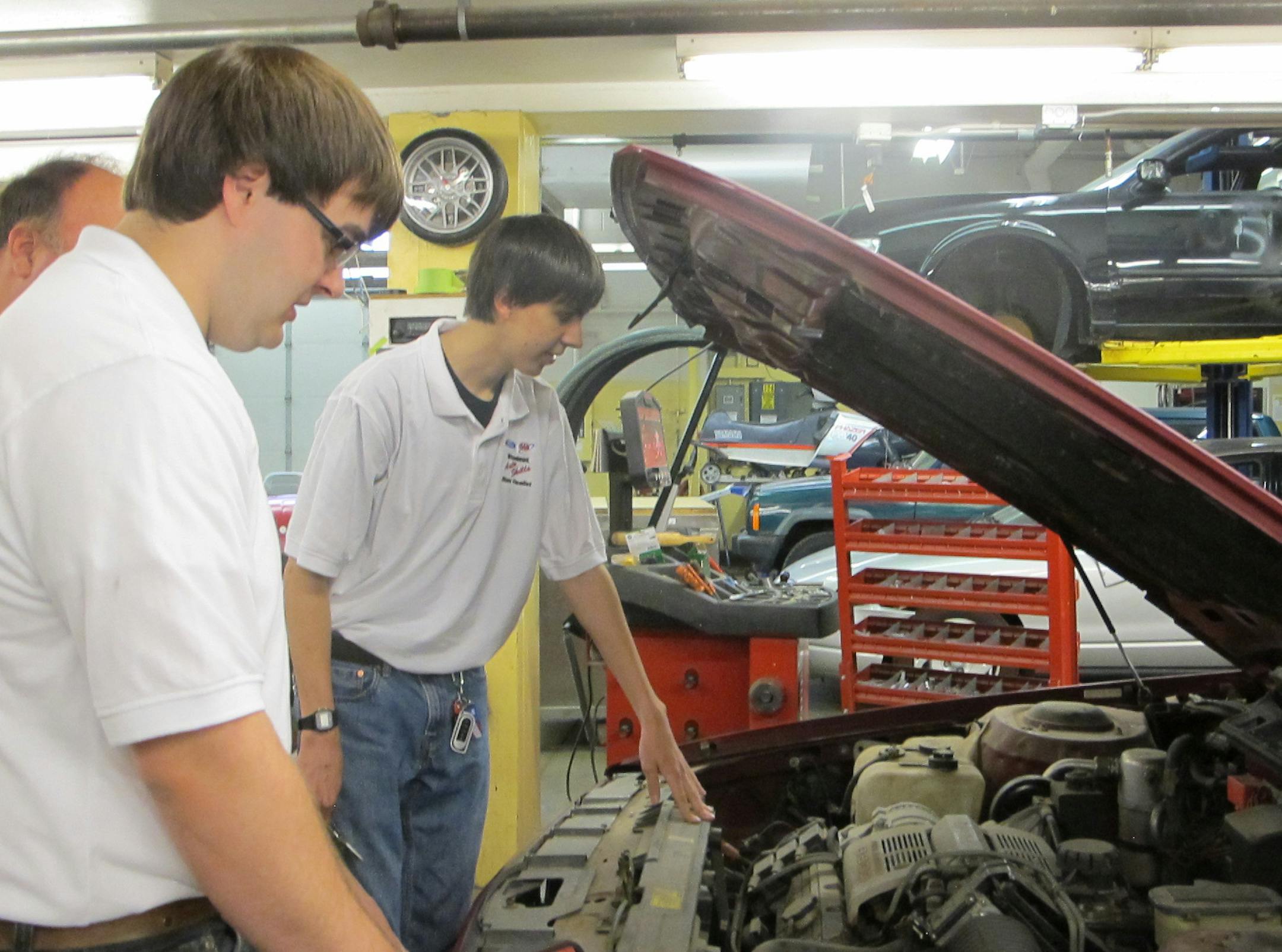 By Erin Adler. Jacob Mischel, teacher Russ Tesmer and Nick Hernandez in the Burnsville High School auto shop.