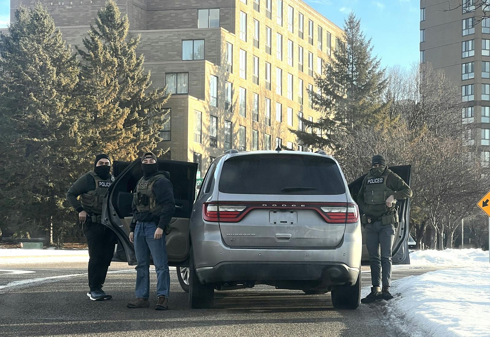 Federal immigration enforcement agents stand outside a Dodge Durango without license plates near an apartment complex in Edina on Jan. 9.