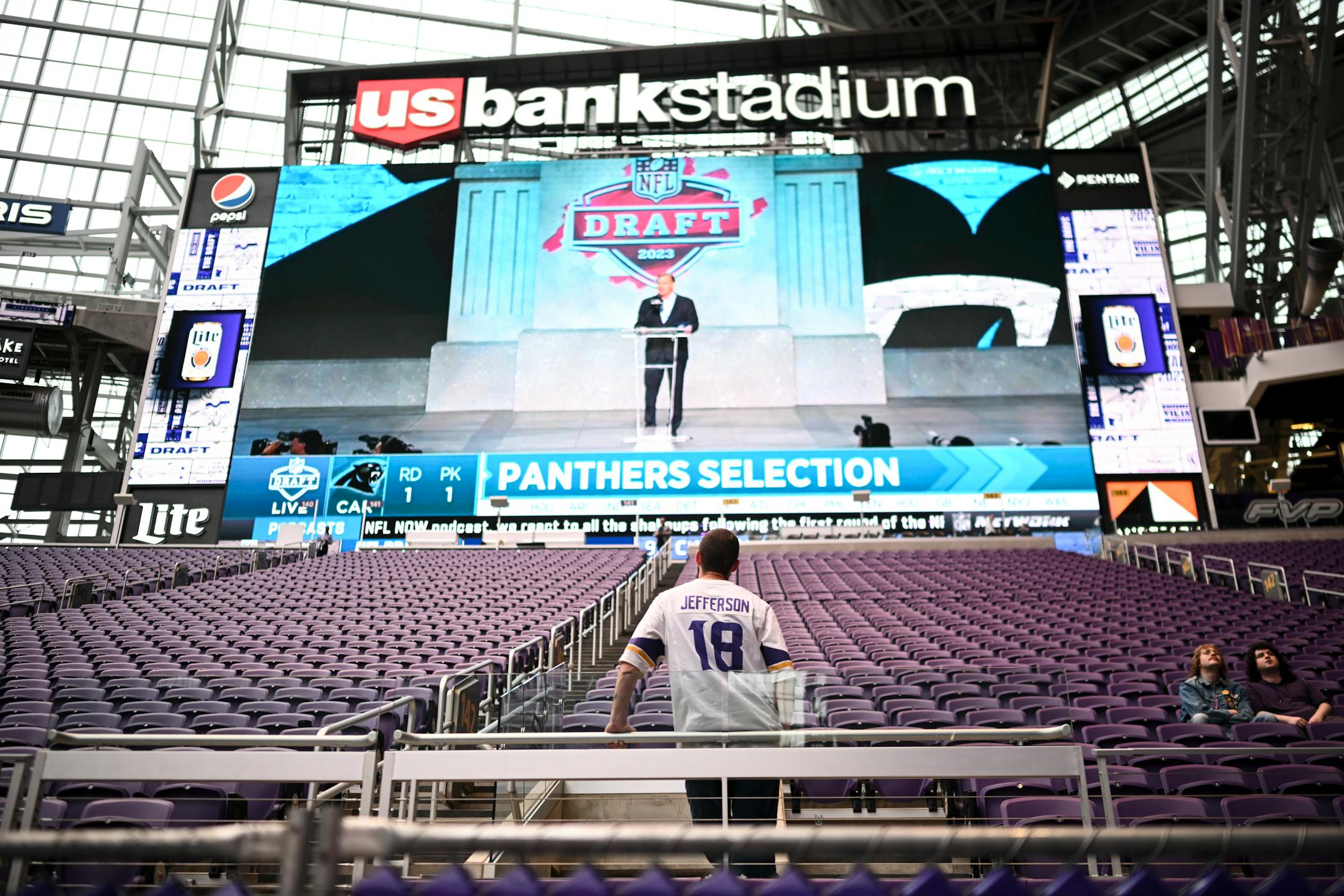 A fan watches the first pick of the draft during the Vikings NFL Draft Party.