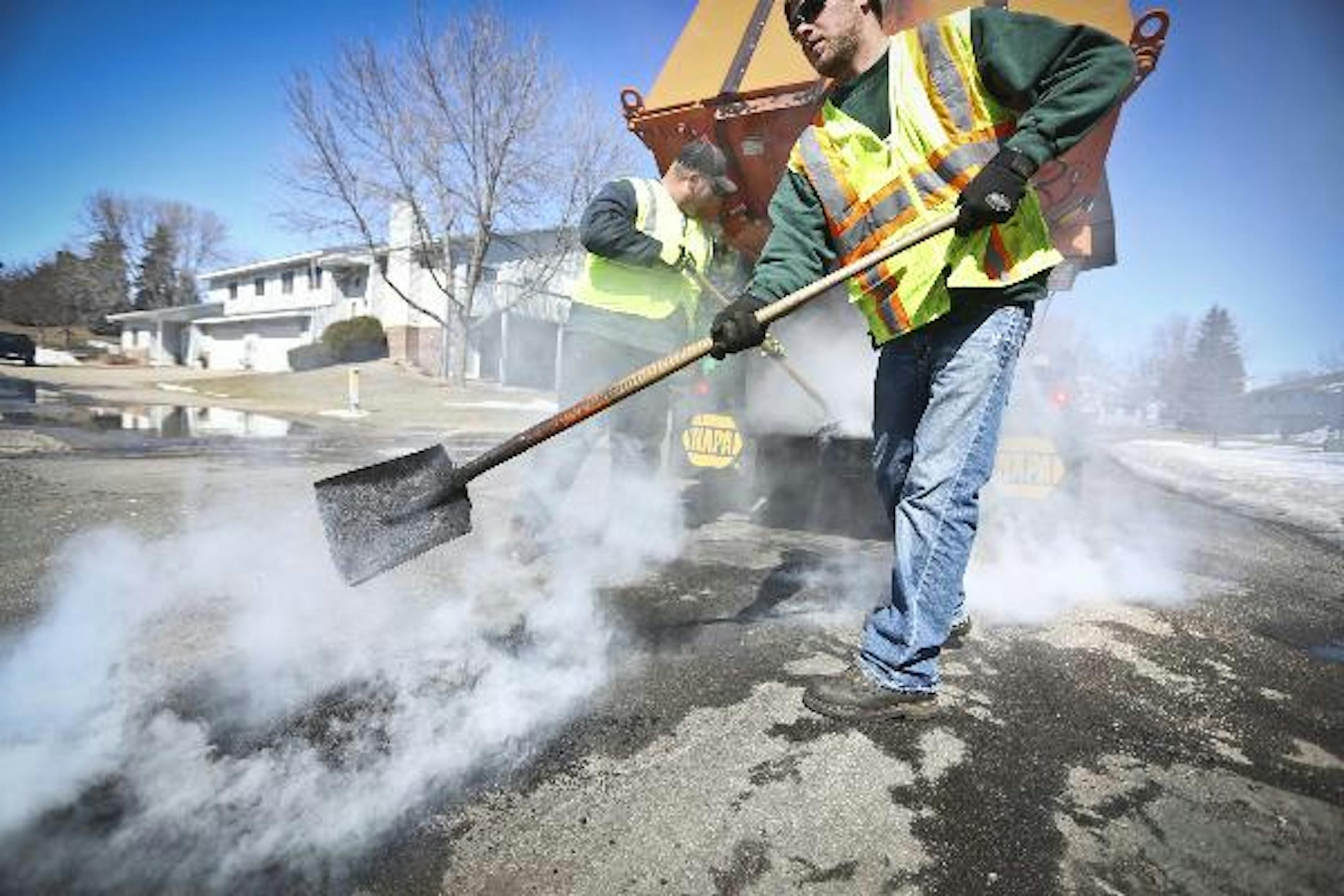 Cam Killmer (right) and Andrew Wheeler covered potholes with black top on a street in Burnsville on Monday , April 1, 2013 in Burnsville, Minn. ] (RENEE JONES SCHNEIDER * reneejones@startribune.com)Cam Killmer and call reporter on celll to confrim time = 612 310 1077