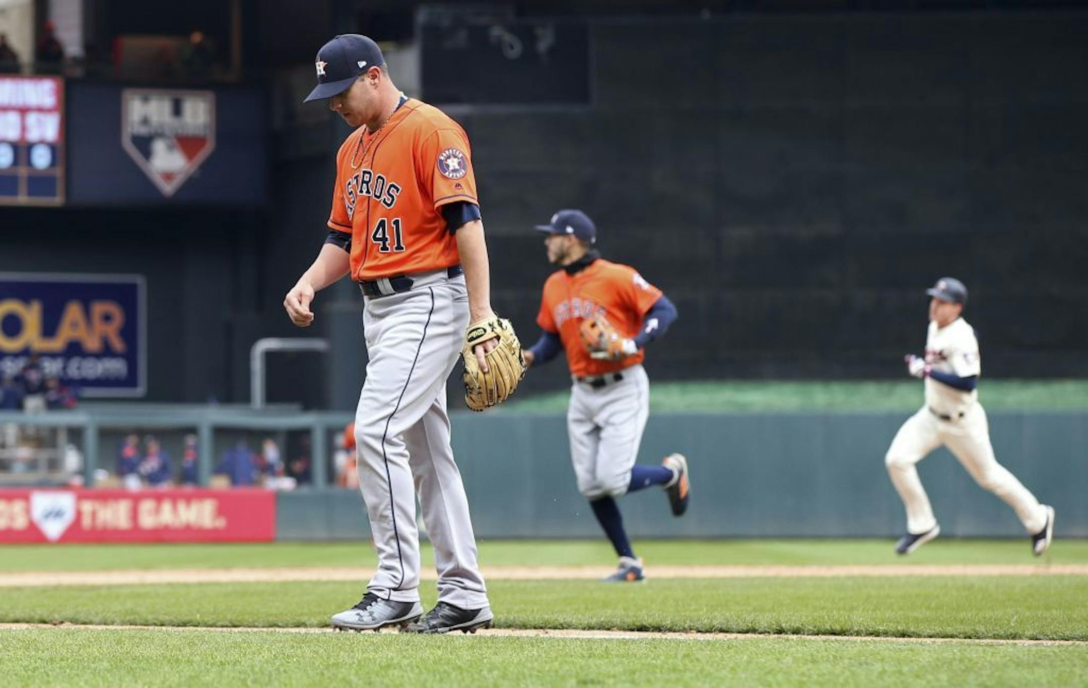 Houston Astros pitcher Brad Peacock, left, walks to the dugout after giving up the game-winning walkoff home run to Minnesota Twins' Max Kepler, right, in the ninth inning of a baseball game Wednesday, April 11, 2018, in Minneapolis. The Twins won 9-8. Peacock picked up the loss.