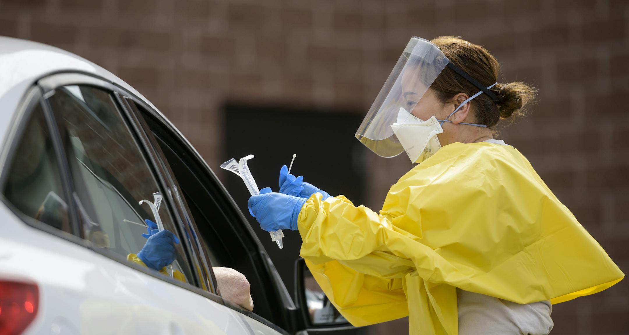 Elizabeth Santoro, a medic with the Minnesota Air National Guard 133rd Medical Group, administered a free COVID-19 test to a passenger at the drive-up testing site behind the Minneapolis Armory, Saturday, May 23, 2020, in Minneapolis. The Minnesota National Guard offered free COVID-19 testing at the Minneapolis Armory. Several free testing locations across the state were operated by the National Guard, the Minnesota Dept. of Health and the State Emergency Operations Center. (Aaron Lavinsky/Star