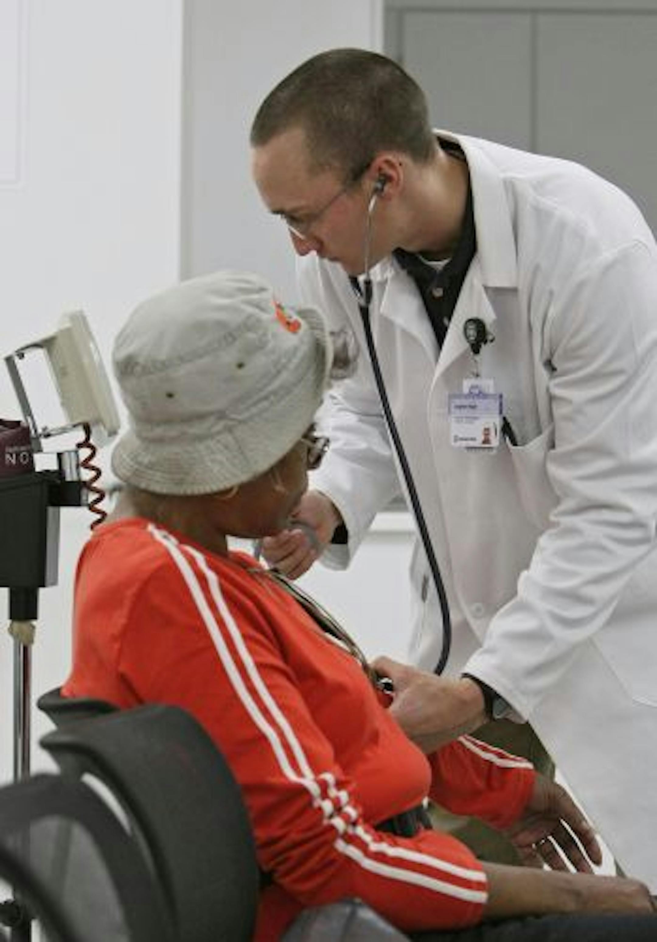 Cleveland Clinic exercise physiologist Jonathan Naylor takes Dorothy Roberts' blood pressure before a cardiac rehabilitation class Monday, Dec. 21, 2009, Cleveland. Researchers found people who completed all 36 sessions of cardiac rehabilitation that Medicare covers were less likely to die or suffer a heart attack in the following three to four years.