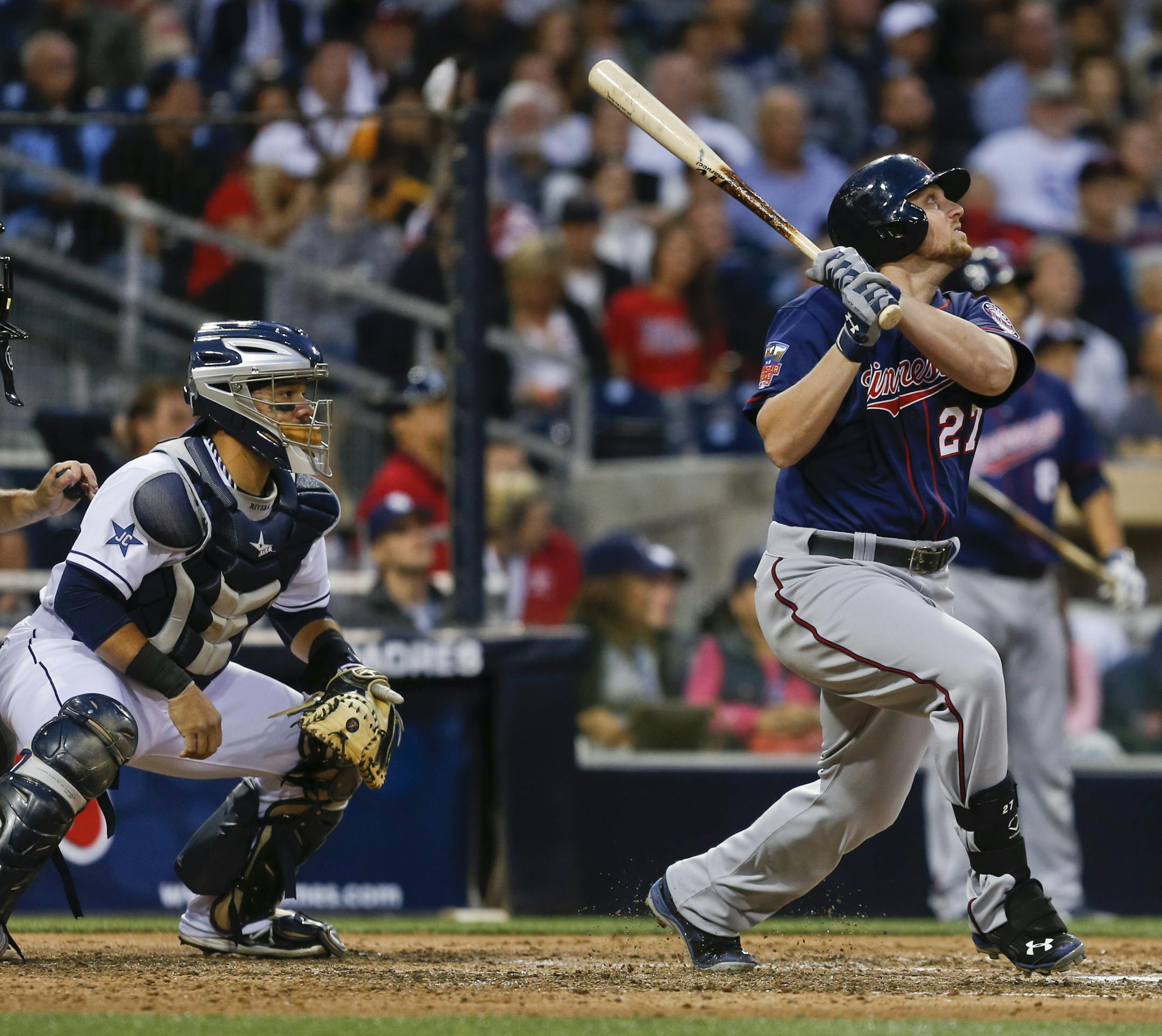 Minnesota Twins' Chris Parmelee and San Diego Padres catcher Rene Rivera watch Parmelee's sacrifice fly to left field that brought in Joe Mauer from third with the game's first run, during the sixth inning of a baseball game Wednesday, May 21, 2014, in San Diego. (AP Photo/Lenny Ignelzi)