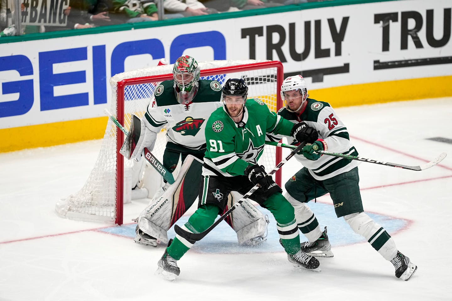 Dallas Stars center Tyler Seguin (91) pressures the net as Minnesota Wild goaltender Filip Gustavsson gets help on the play from Jonas Brodin (25) during Game 1 of an NHL hockey Stanley Cup first-round playoff series, Tuesday, April 18, 2023, in Dallas. (AP Photo/Tony Gutierrez)