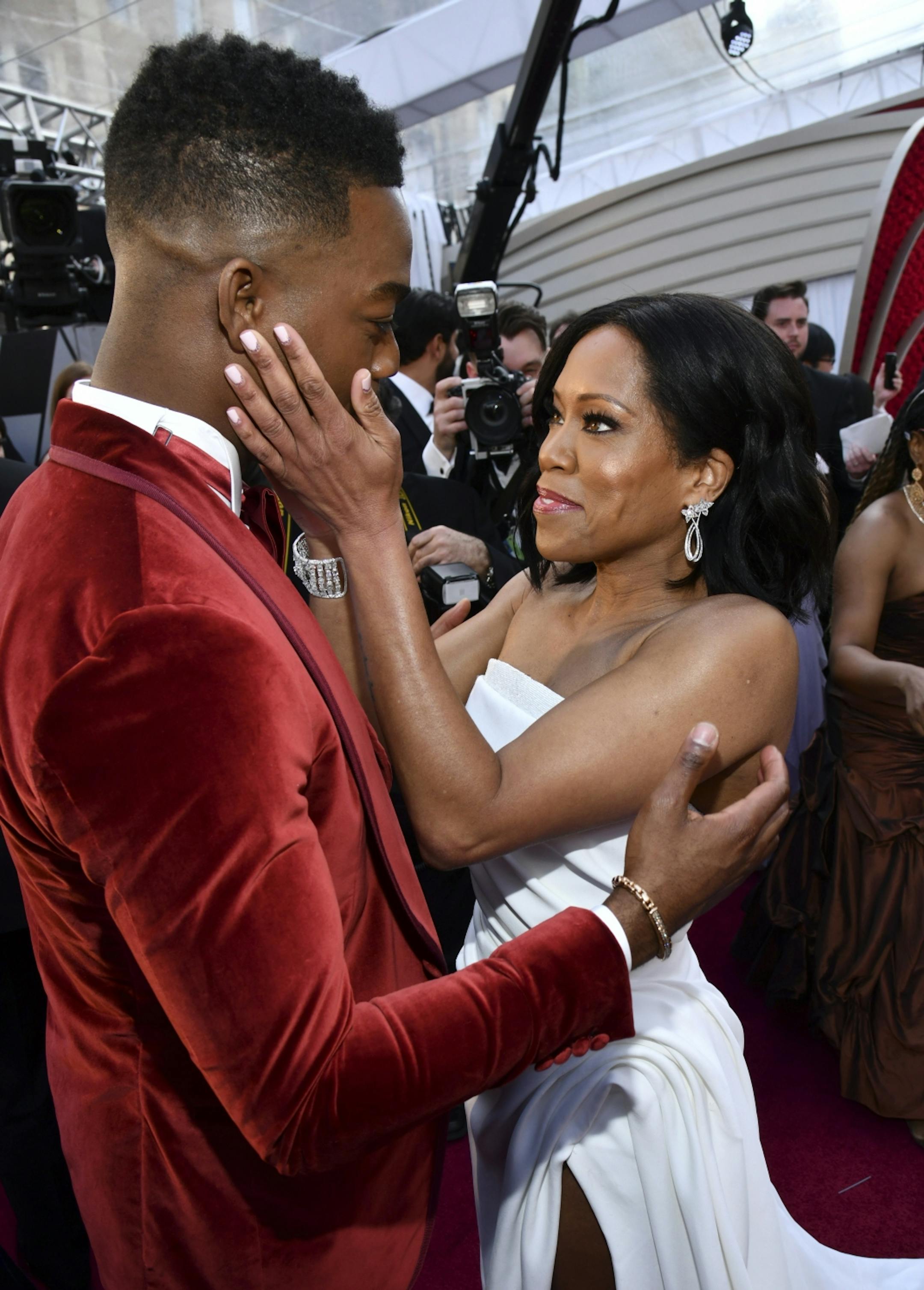 Stephan James, left, and Regina King greet one another as they arrive at the Oscars on Sunday, Feb. 24, 2019, at the Dolby Theatre in Los Angeles.