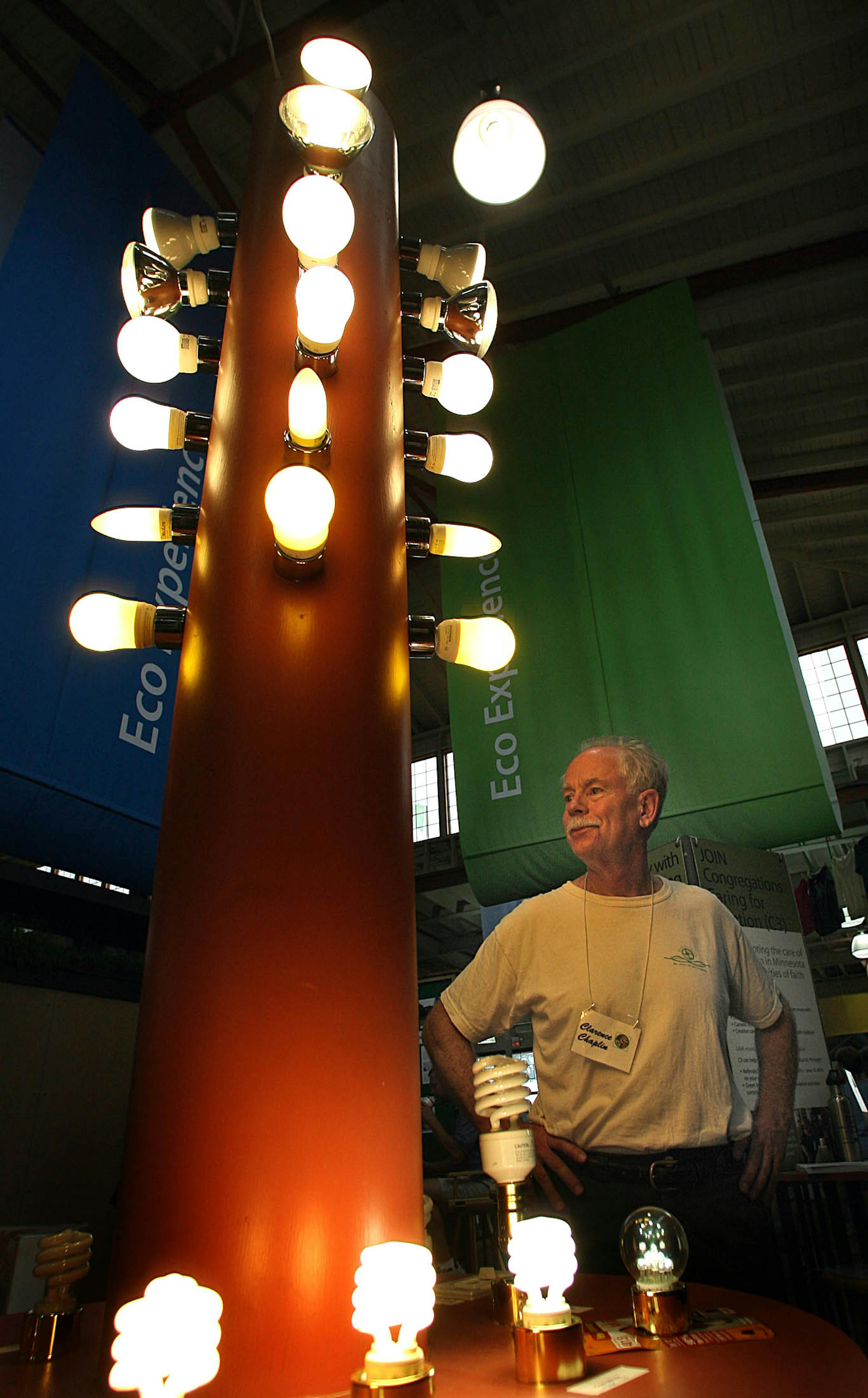 Clarence Chaplin stood near a display that provided information about compact fluorescent light bulbs at the Eco Experience at the Minnesota State Fair, where he volunteers, helping Congregations Caring for Creation show church groups how to go green.