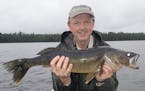 Star Tribune outdoor writer Doug Smith with a walleye he caught on a July fishing trip to Quetico Provincial Park in Ontario. Smith retired Oct. 30 fr