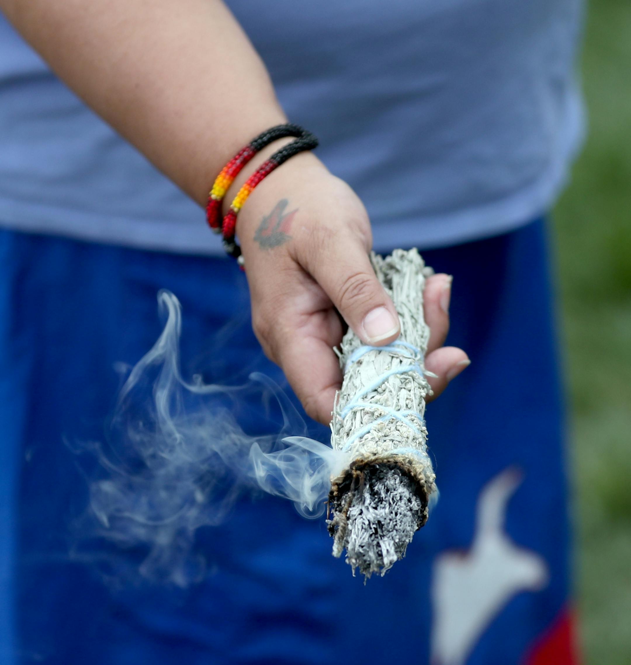 A controversial new sculpture at the Walker Art Center that prompted an outcry among Minnesota's American Indian communities will be dismantled, the director said Saturday. Here, Janice Bad Moccasin, a Hunkpati Dakota living in Shakapee held burning sage while speaking with protestors outside the Walker Sculpture Garden Saturday, May 27, 2017, in Minneapolis, MN.