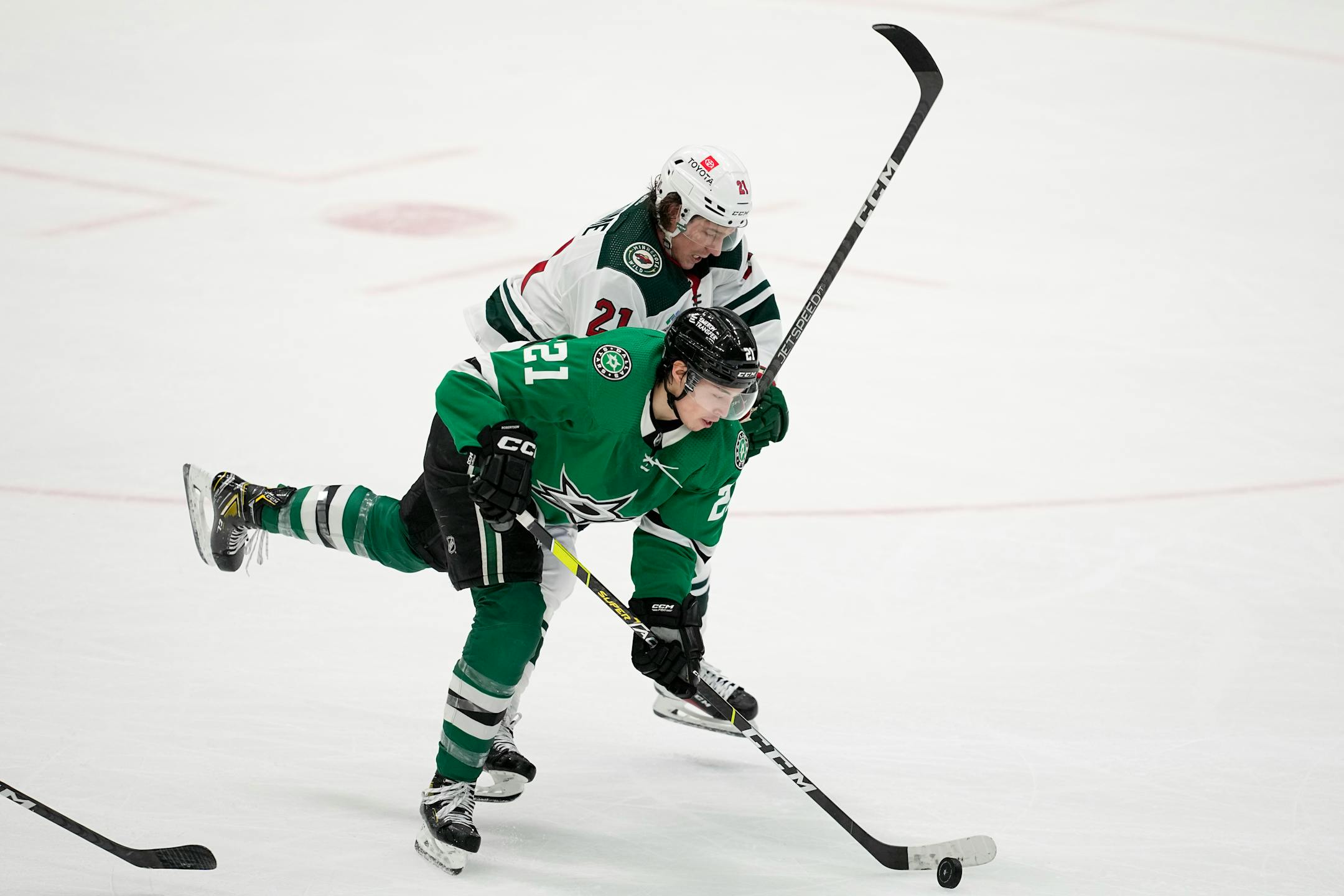Dallas Stars left wing Jason Robertson, front, takes control of the puck in front of Minnesota Wild right wing Brandon Duhaime, rear, in the third period of Game 1.