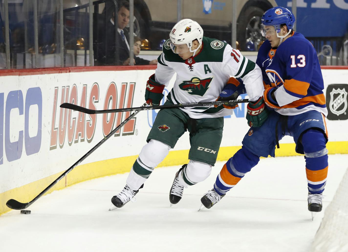 Zach Parise (11) of the Wild and Mathew Barzal of the Islanders battled for the puck Monday.