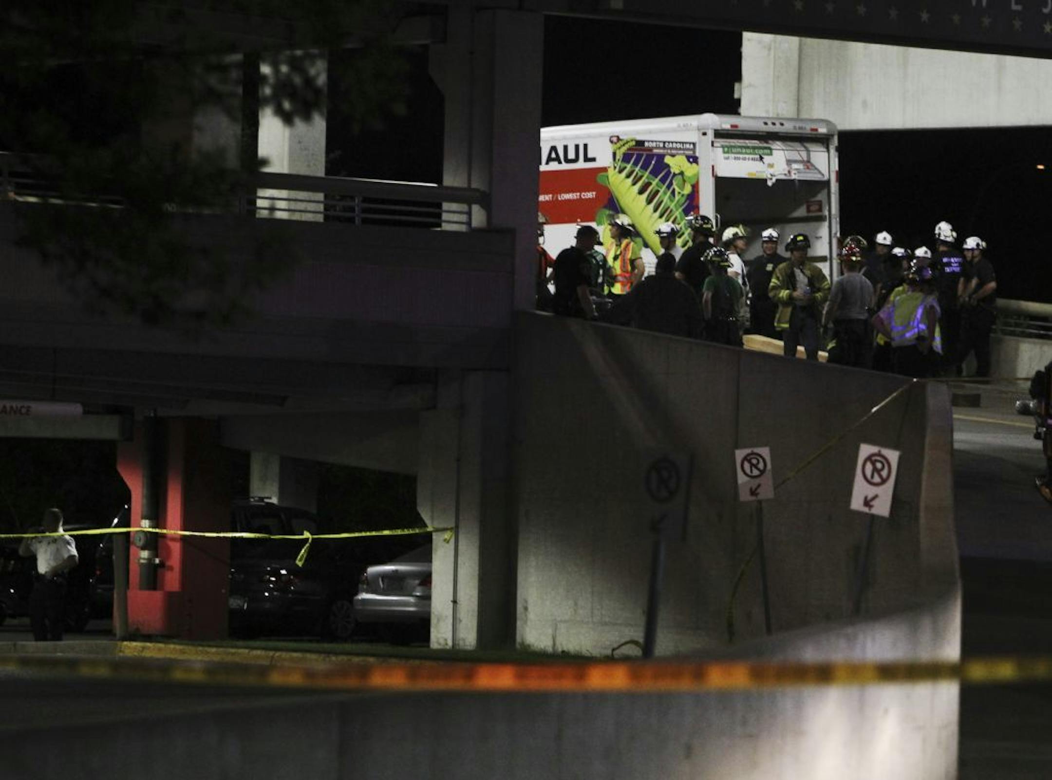 Emergency workers surround a U-Haul trunk after a chunk of concrete in the MOA west parking ramp near Nordstrom broke loose and fell on it Friday, Aug. 3, 2012.