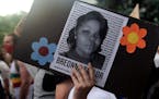 A demonstrator holds a sign with the image of Breonna Taylor, a black woman who was fatally shot by Louisville Metro Police Department officers, durin