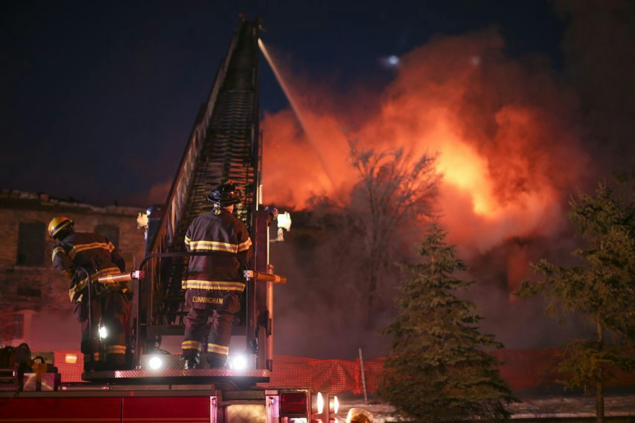 Minneapolis firefighters dumped water on the burning Harris Machinery Co. warehouse Sunday evening. Due to the cold, firefighters had to be rotated through in shorter shifts.