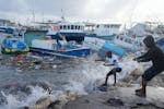 Fishermen pull a boat damaged by Hurricane Beryl back to the dock at the Bridgetown Fisheries in Barbados, Monday, July 1, 2024. (AP Photo/Ricardo Maz