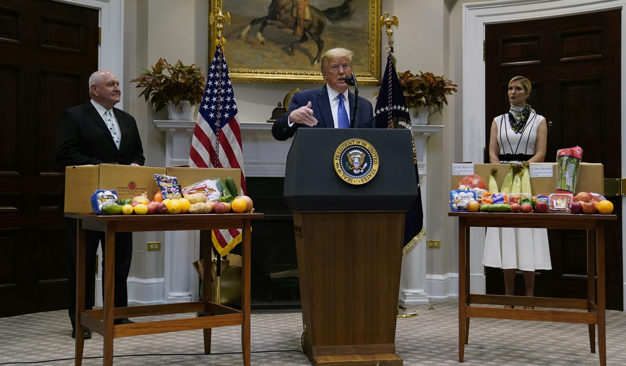 President Donald Trump speaks about the food supply chain during the coronavirus pandemic, in the Roosevelt Room of the White House, Tuesday, May 19, 2020, in Washington. Agriculture Secretary Sonny Perdue, left, and Ivanka Trump, the daughter of President Donald Trump, listen. (AP Photo/Evan Vucci) ORG XMIT: DCEV420