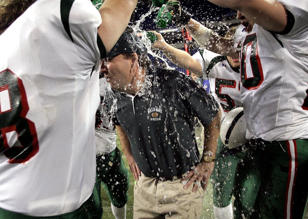 His players doused East Grand Forks head coach Bruce Nelson with water to celebrate their title.