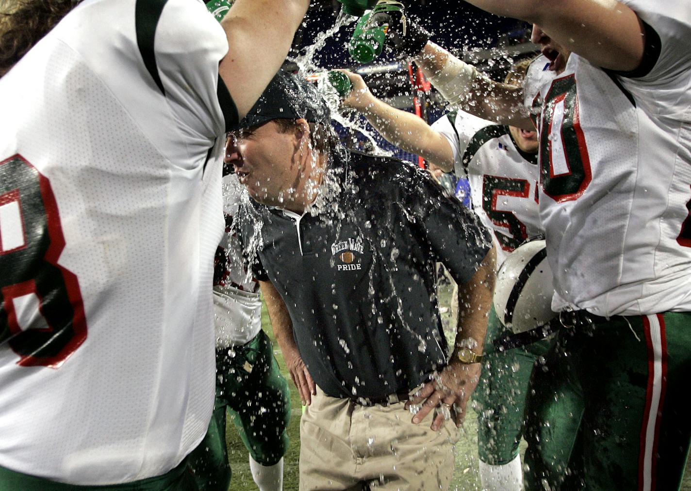 Carlos Gonzalez/Star Tribune November 26, 2004- Metrodome ñ Minneapolis, MN ñ Class AAA State Football Tournament- East Grand Forks vs. Becker ñ East Grand Forks head coach Bruce Nelson is doused with water by his team at the end of Friday nightís championship game. East Grand Forks beat Becker by a final score of 31-14.