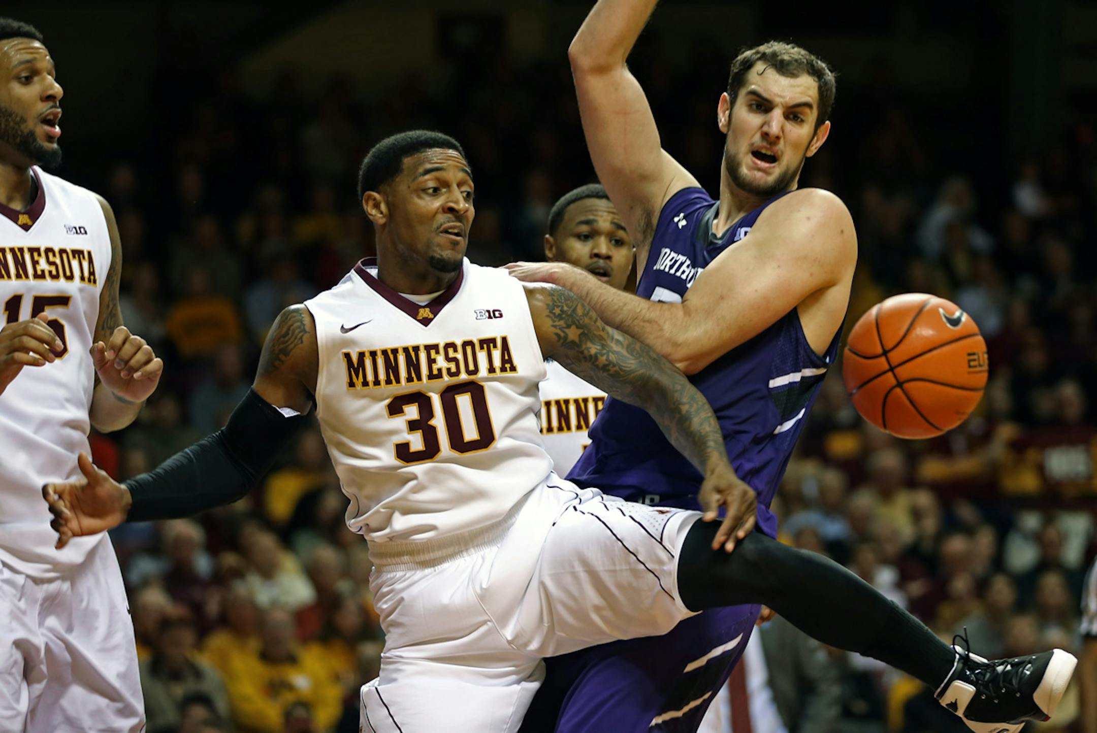 Minnesota's Malik Smith and Northwestern's Alex Olah chased a loose ball in first half action. at Williams Arena.