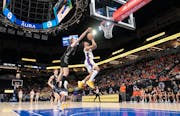The action goes on near the rim as Cretin-Derham Hall guard Jason Johnson drives for a layup challenged by Farmington’s Tyler Beckwith.