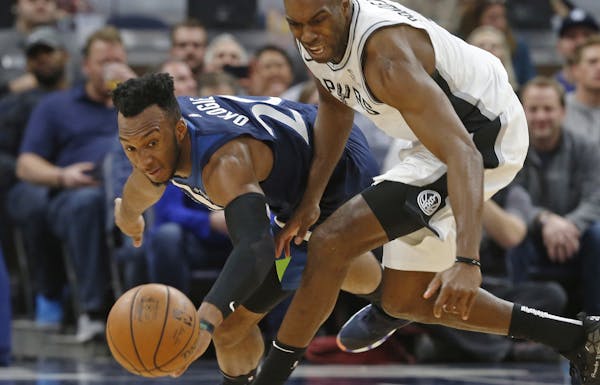 Minnesota Timberwolves' Josh Okogie, left, of Nigeria, and San Antonio Spurs' Quincy Pondexter chase the loose ball in the second half of an NBA baske