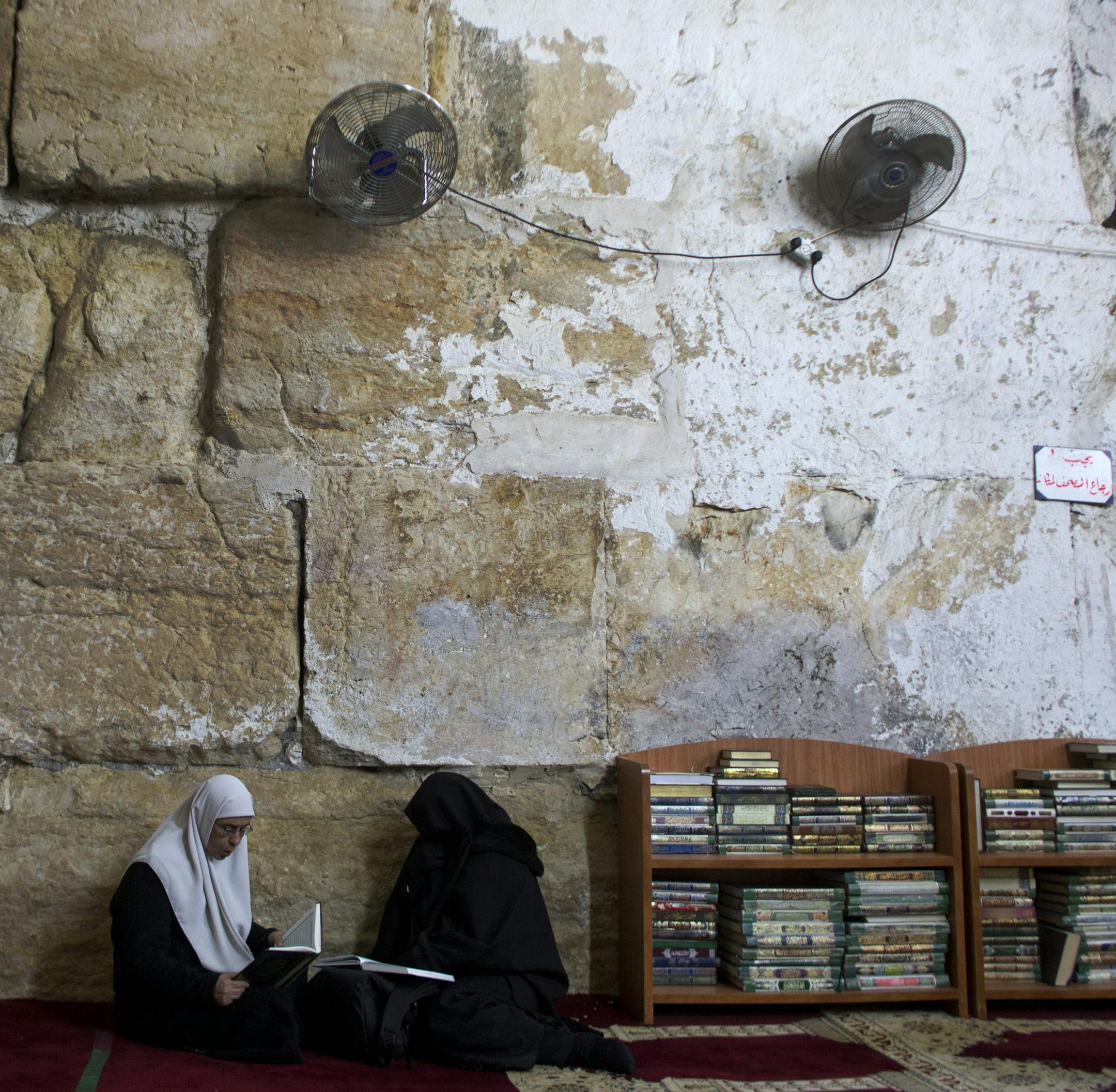 In this photo taken on Monday, Jan. 27, 2014, Palestinian women read at the al-Aqsa mosque compound library in Jerusalem. The library has a collection of some 4,000 old manuscripts with about a quarter considered in poor condition. Half of the books are already undergoing restoration funded by the Waqf, Jordanís Islamic authority which manages the holy site, and with assistance from UNESCO. (AP Photo/Dusan Vranic)