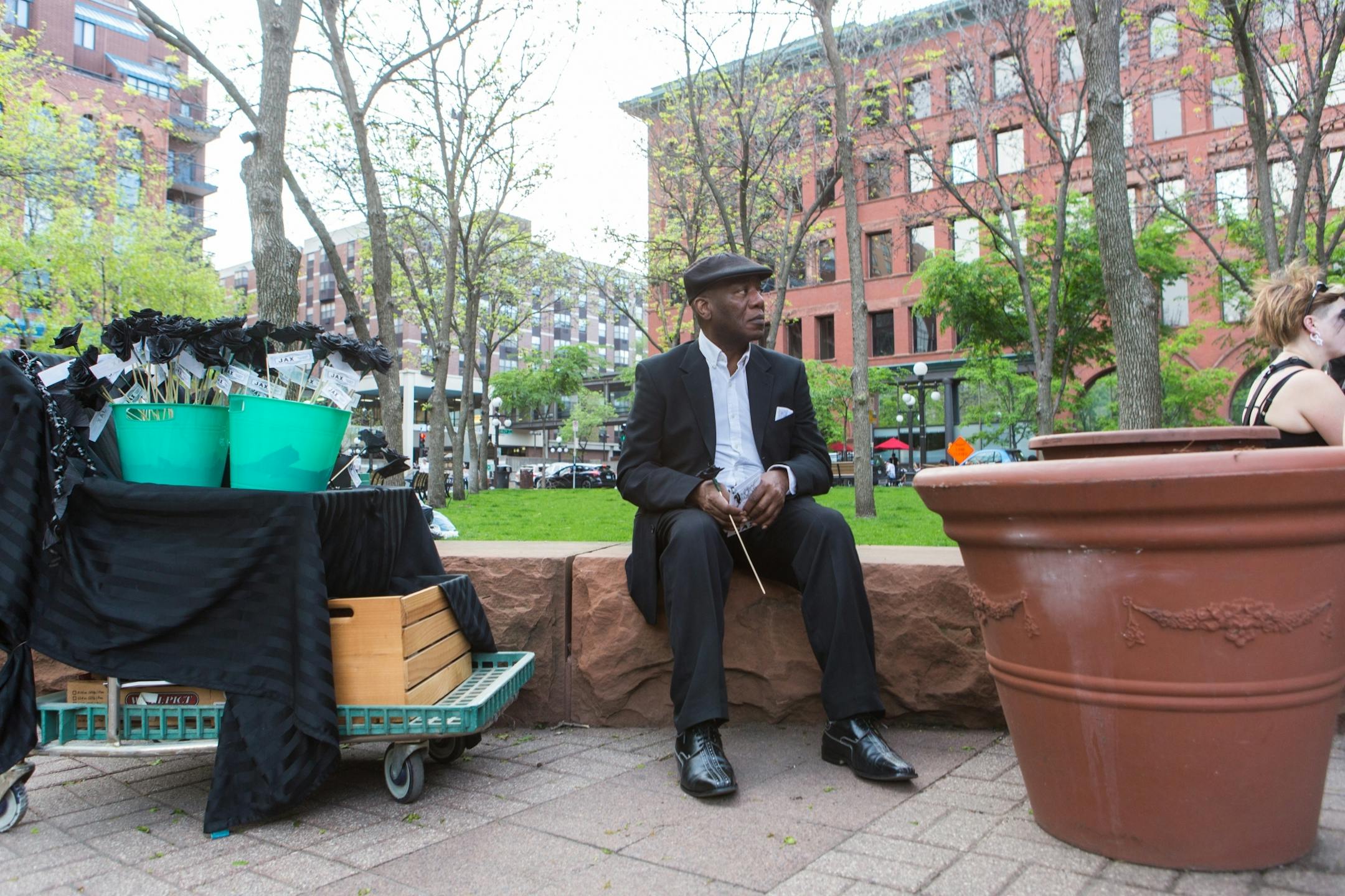 Frank Brown, who has lived in Lowertown for 18 years, said, "I moved to Lowertown because of the community." He watched the funeral while holding a flower in support in Mears Park Friday evening.