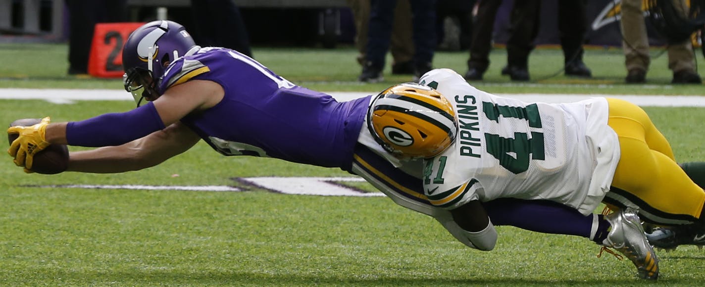 Minnesota Vikings wide receiver Adam Thielen (19) reaches for yardage as Green Bay Packers cornerback Lenzy Pipkins (41) makes the tackle in the second half of an NFL football game in Minneapolis, Sunday, Oct. 15, 2017. (AP Photo/Jim Mone)