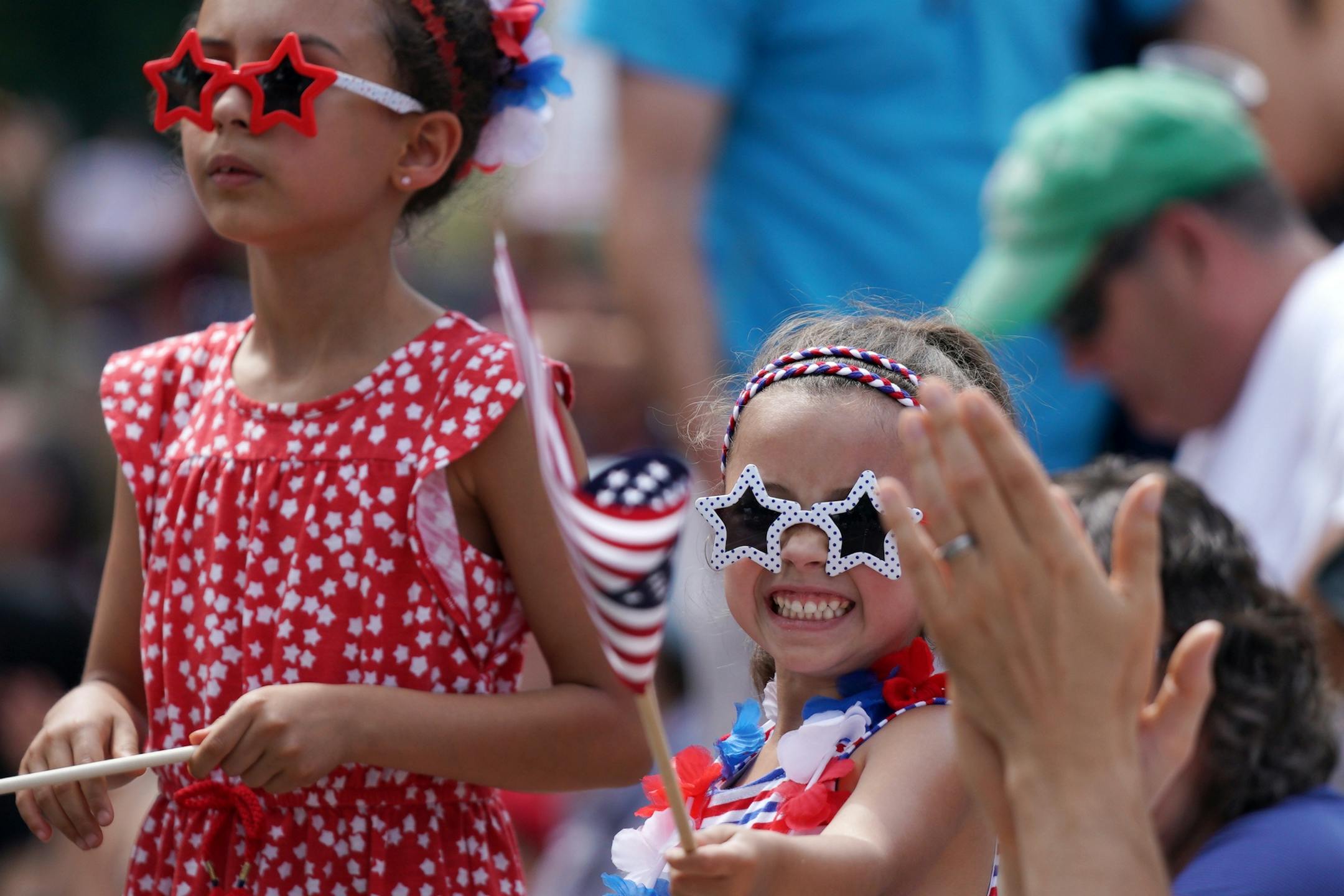 Lucy Jeffrey, 4, waved an American flag as she stood with her sister Julia, 6, during the St. Anthony Park neighborhood 4th in the Park parade.