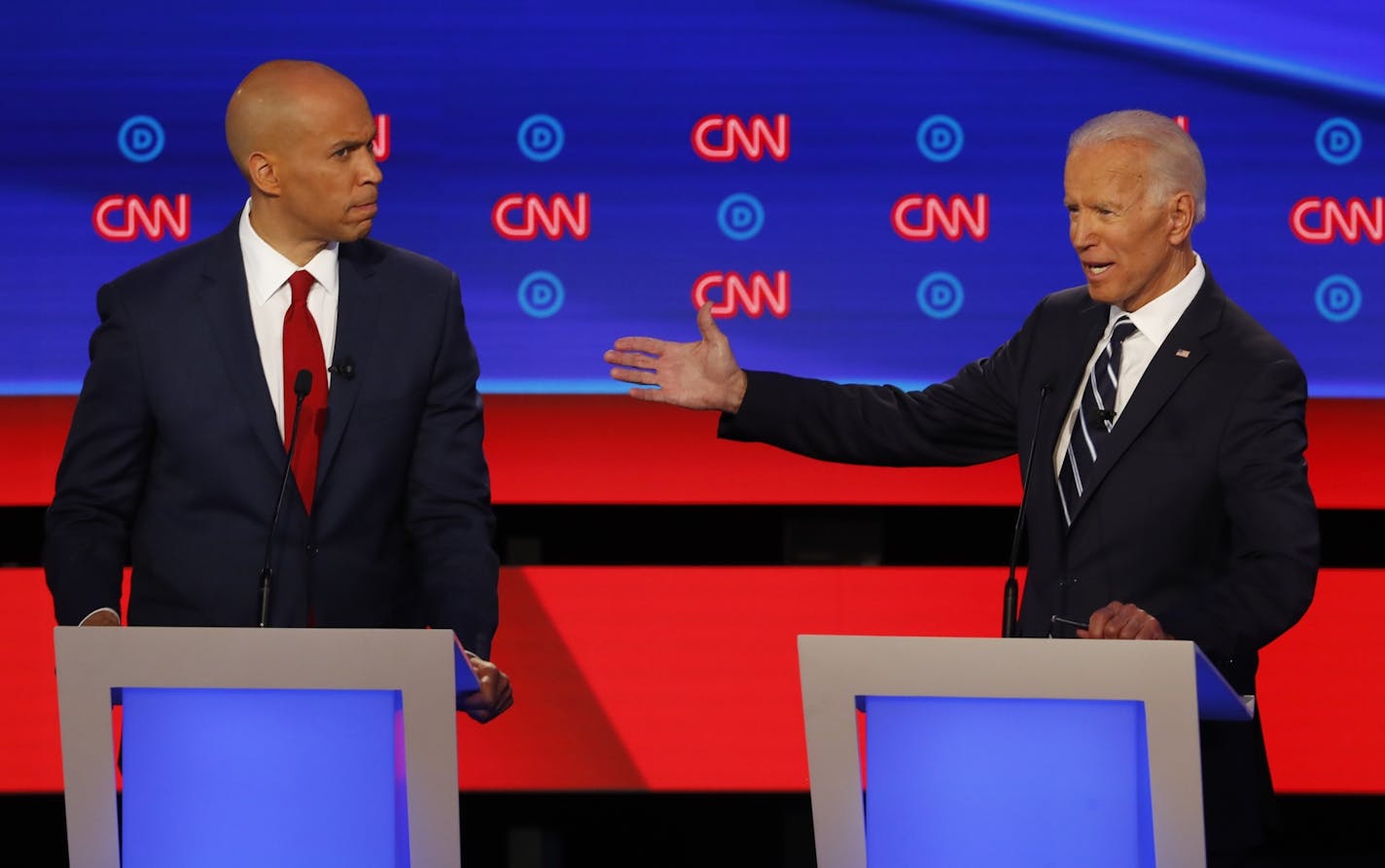 Sen. Cory Booker, D-N.J., listens to former Vice President Joe Biden during the second of two Democratic presidential primary debates hosted by CNN Wednesday, July 31, 2019, in the Fox Theatre in Detroit. (AP Photo/Paul Sancya)