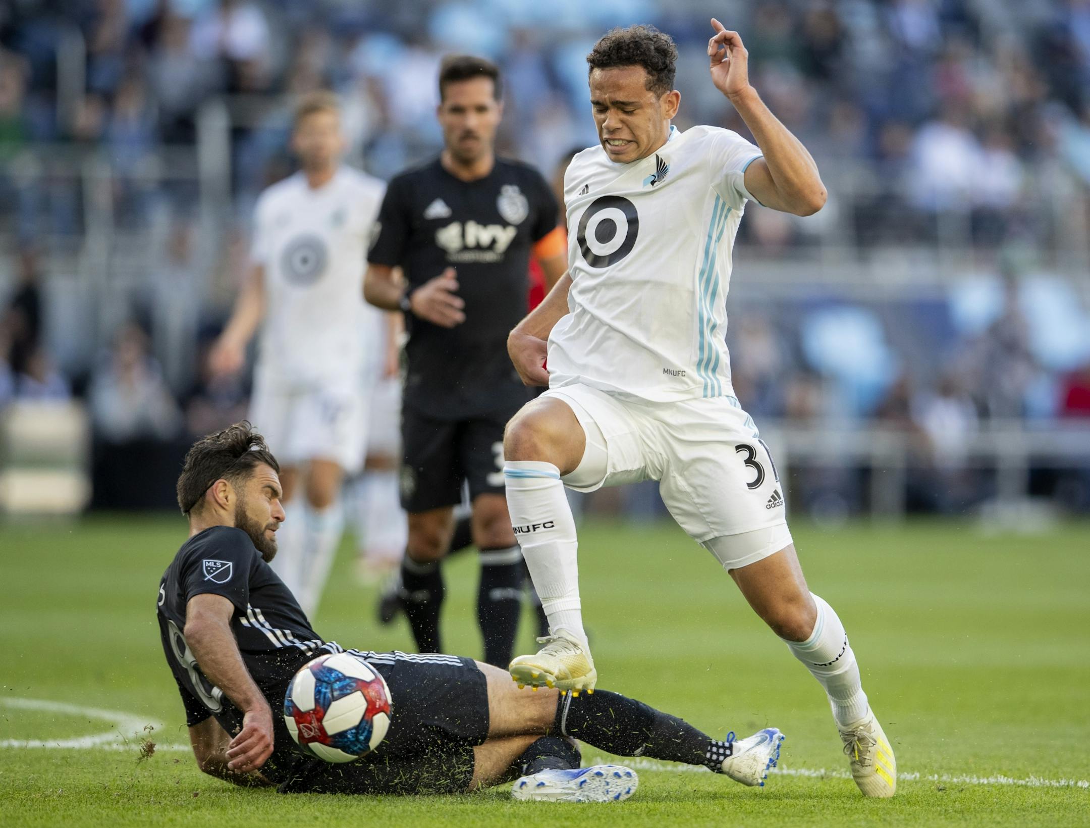 Graham Zusi (8) Sporting Kansas City and Hassani Dotson (31) of Minnesota United FC fought for the ball in the first half.