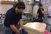 Waconia High School teacher David Aeling works on a wood cabinet at ELKAY &#xf1; Medallion Cabinetry plant in Waconia. The teacher is taking part in a