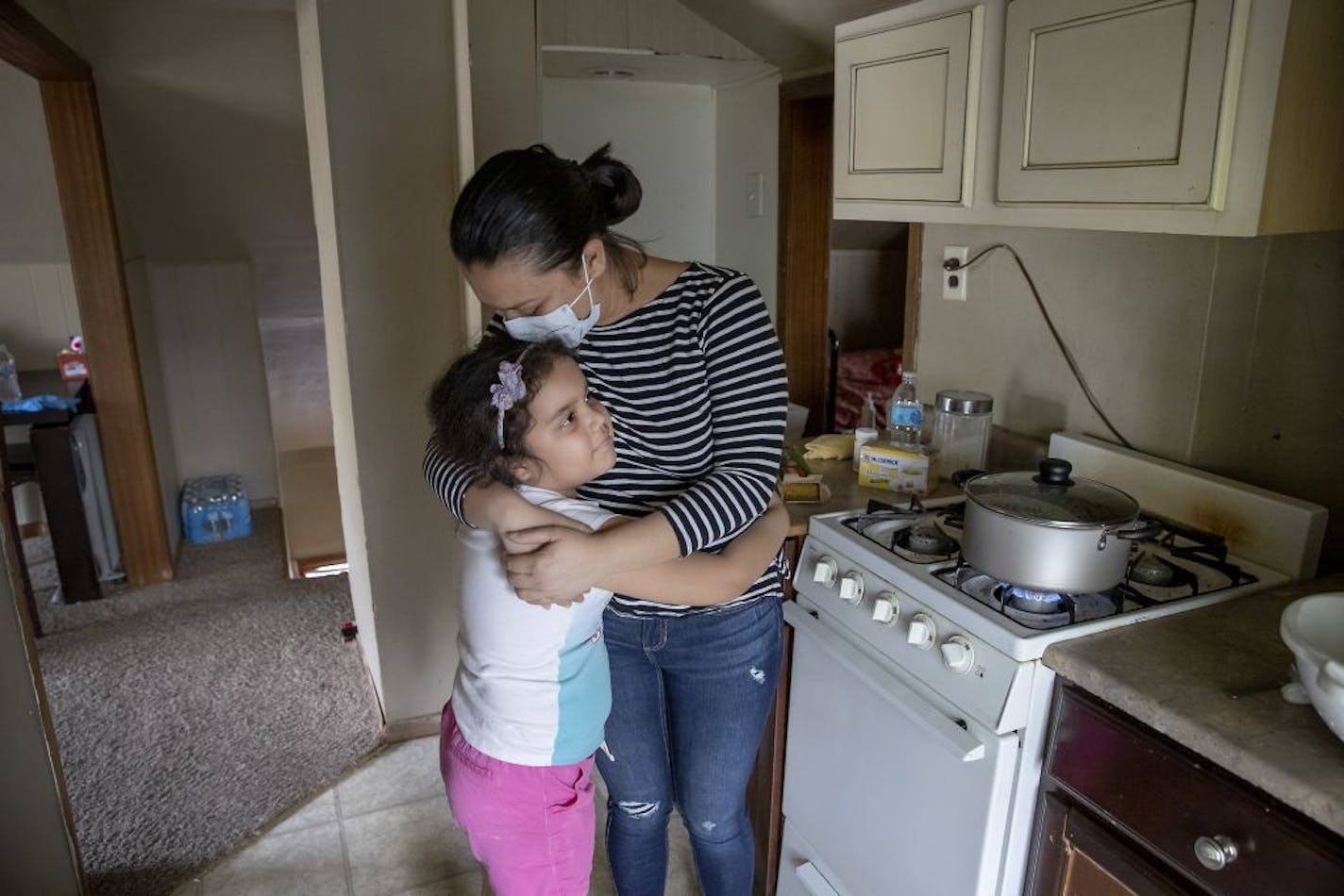 "My daughter fed me and gave me tea when I was sick," said Jomari of her daughter Estefany, 8, while cooking in her kitchen, Thursday, May 7, 2020 in Willmar, MN. Jamari worked in the sanitation department for a company (not using name of it) inside the Jenny-O plant since last October. She just completed her quarantine and is hopeful of returning to work on Monday.