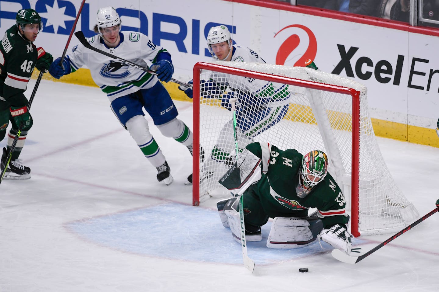 Minnesota Wild goalie Cam Talbot, right, stops a shot as Wild defenseman Jared Spurgeon (46) and Vancouver Canucks right wing Vasily Podkolzin, second from left, and right wing Alex Chiasson during the third period of an NHL hockey game Thursday, March 24, 2022, in St. Paul, Minn. The Wild won 3-2 in overtime. (AP Photo/Craig Lassig)