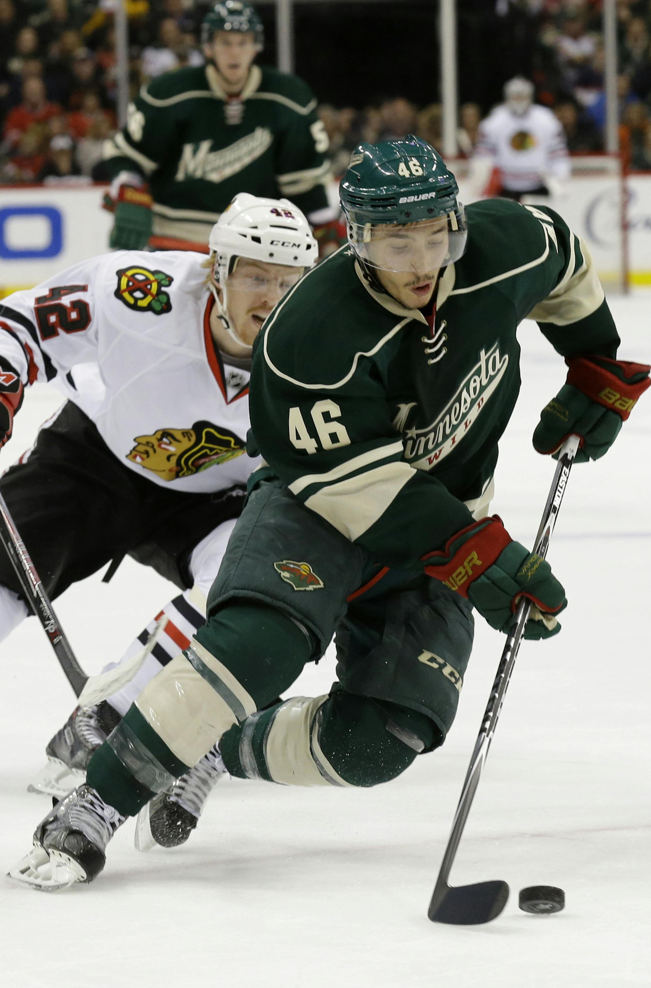 Minnesota Wild defenseman Jared Spurgeon (46) controls the puck in front of Chicago Blackhawks center Joakim Nordstrom (42), of Sweden, during the second period of Game 6 of an NHL hockey second-round playoff series in St. Paul, Minn., Tuesday, May 13, 2014. (AP Photo/Ann Heisenfelt)