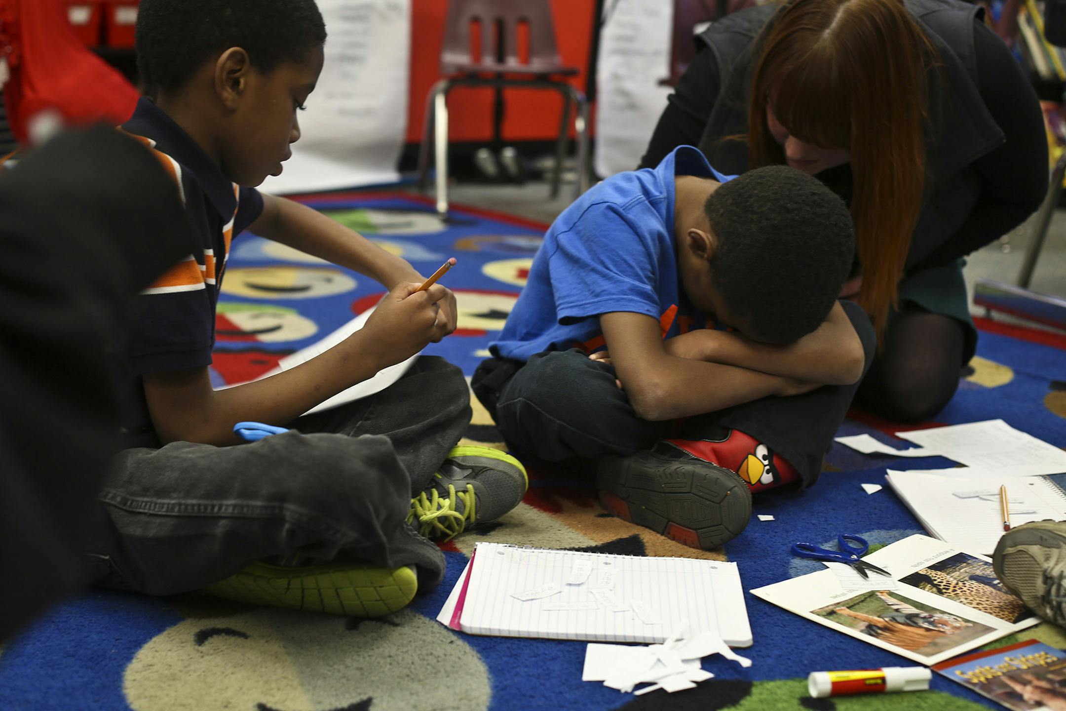 A third grade boy had an emotional moment during a reading exercise before being calmed down by teacher's assistant Sarah Johnson, right, at Hamline Elementary School on Friday, November 8, 2013. Hamline is one of St. Paul's schools that caused an uproar by moving nearly 300 EBD children our of their self-contained units into mainstream classes when the school year began. ] RENEE JONES SCHNEIDER ¬• reneejones@startribune.com ORG XMIT: MIN1312041637510877