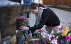 Neighbor Jenelle Masterson puts flowers left at the memorial earlier in the evening into a vase while tending to the memorial for Justine Ruszczyk Dam