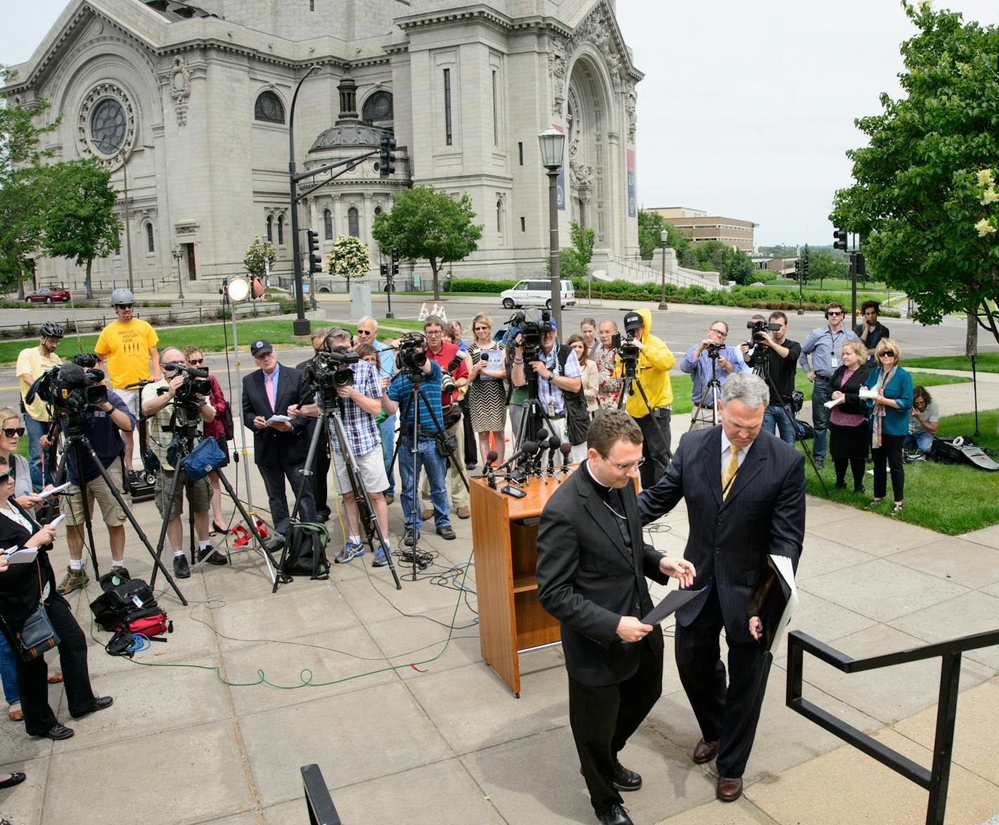 Auxiliary Bishop Andrew Cozzens climbed up the Chancery steps after speaking to the media outside the Archdiocese of Saint Paul and Minneapolis in the wake of Archbishop John Nienstedt's resignation. With him is director of communications Tom Halden.