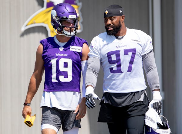 Vikings wide receiver Adam Thielen (19) and defensive end Everson Griffen talked while they walked out for an afternoon practice.