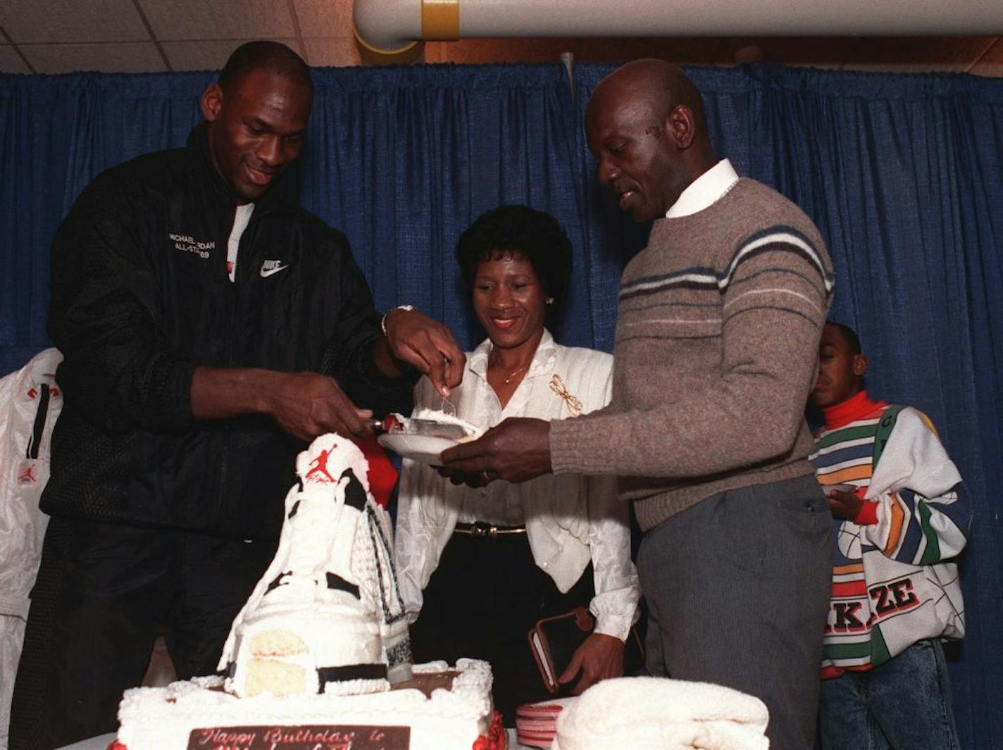 Michael Jordan serves his father, James, right, a slice of birthday cake while his mother, Deloris watches during a party in honor of Jordan's 26th birthday in 1989.