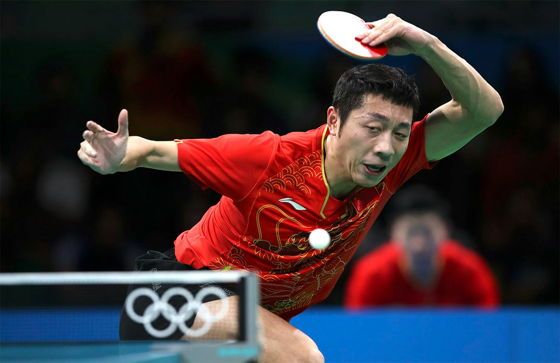 Xu Xin of China plays next to his teammate Zhang Jike against Samuel Walker and Paul Drinkhall of United Kingdom during their men's team table tennis quarter final match at the 2016 Summer Olympics in Rio de Janeiro, Brazil, Sunday, Aug. 14, 2016.