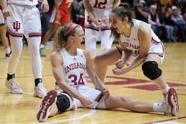 Indiana’s Grace Berger (34) celebrated with Mackenzie Holmes after Berger took a charging foul during last Thursday’s victory against Ohio State. 