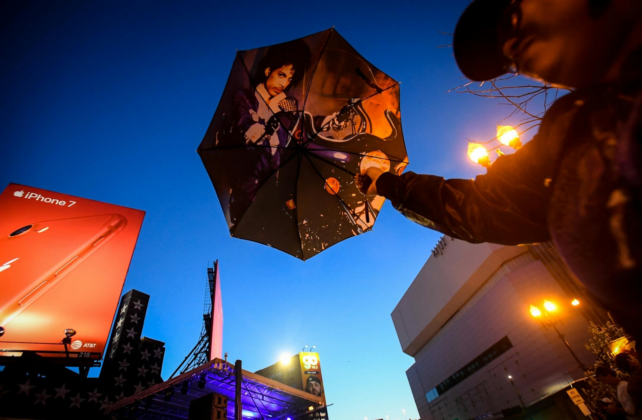 Karen "Special K" Ferguson, of Detroit, held up her Prince umbrella as she watched the Prince Memorial block party from outside the barrier across 7th Street.