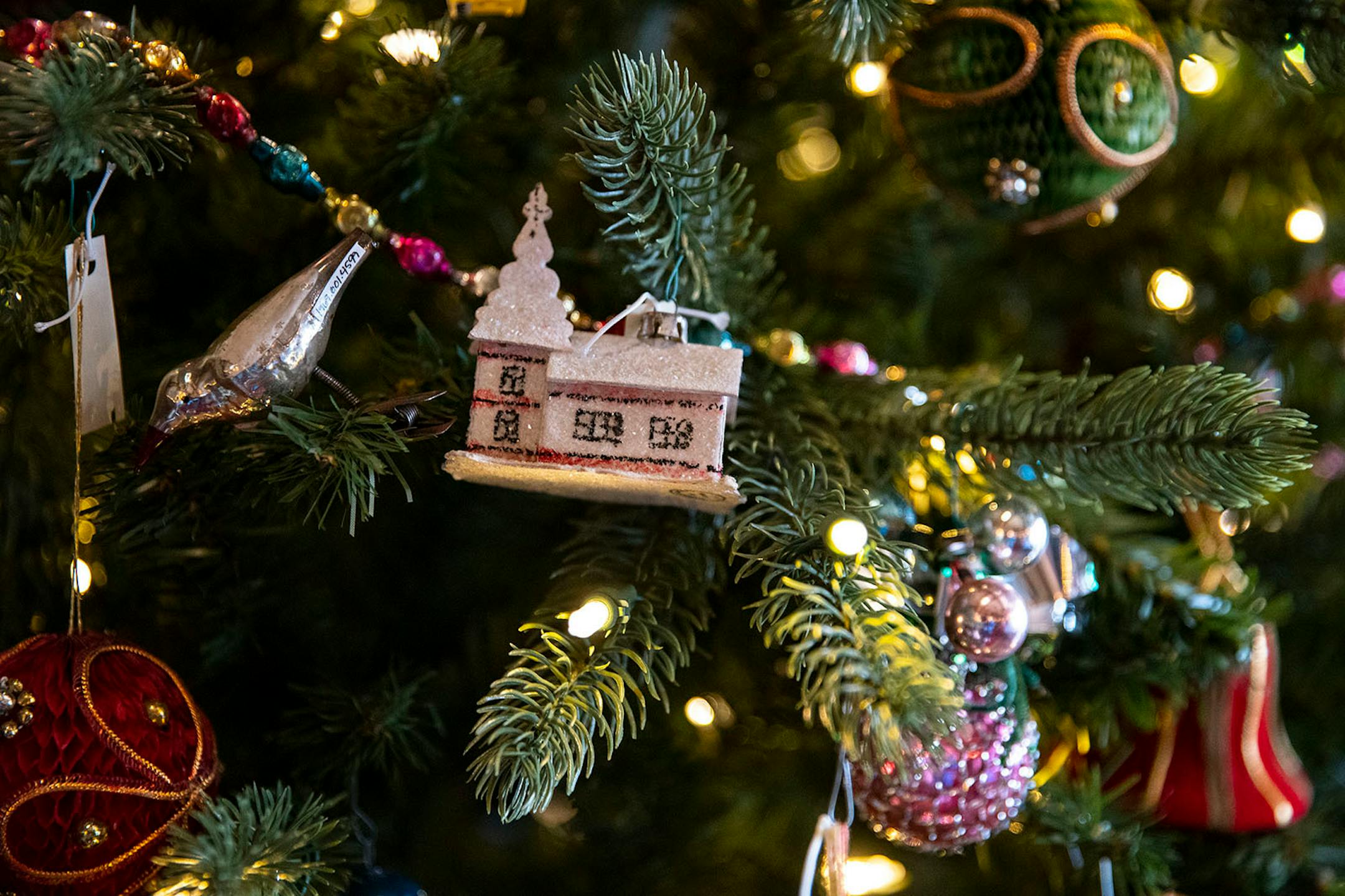 Original decorations from the Congdon family hang on the Christmas tree Glensheen Mansion librayr in Duluth. the mansion has their Christmas decorations in full swing, but with a twist. There are no staff guided tours this holiday season. All tours are self-guided and are being greatly limited to reduce the amount of people inside the mansion at any given time.