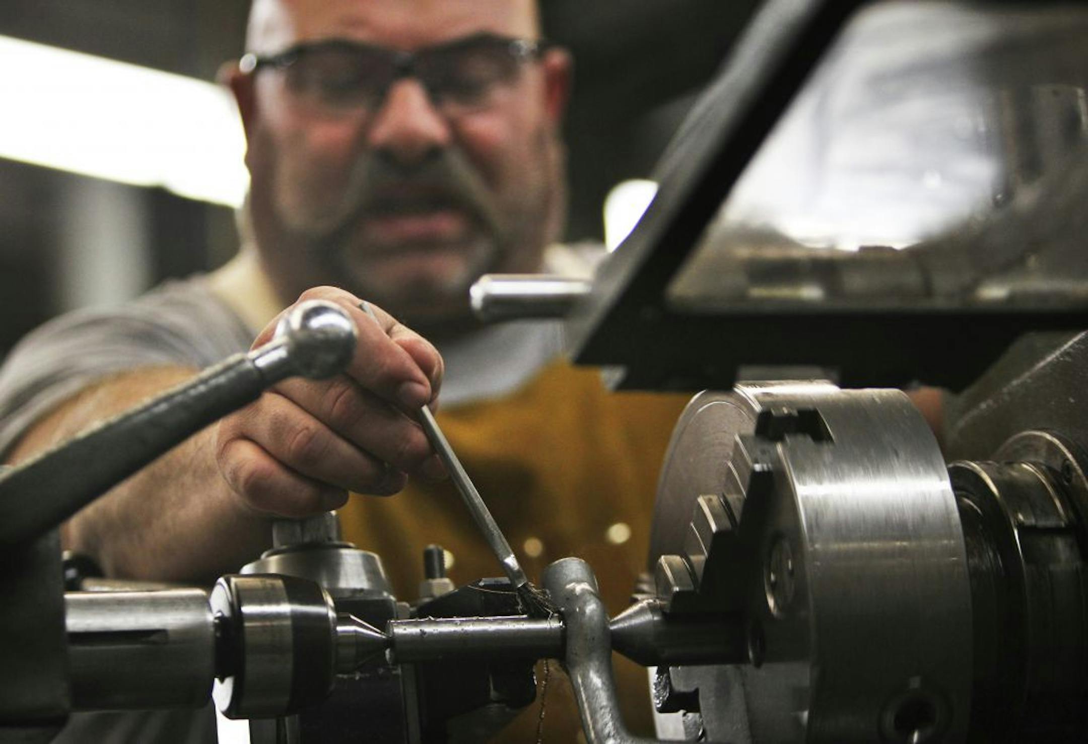 Todd Mills, a machine tool major at MCTC from Lakeville, brushed away metal filings from a metal lathe while cutting a taper in a metal cylinder during machine tool tech Tuesday, Oct. 25, 2011, at MCTC in Minneapolis, MN. According to Mills instructor Kim Munson, there are nine positions available in the field for every graduate that comes out of the program and placement is 100 percent.