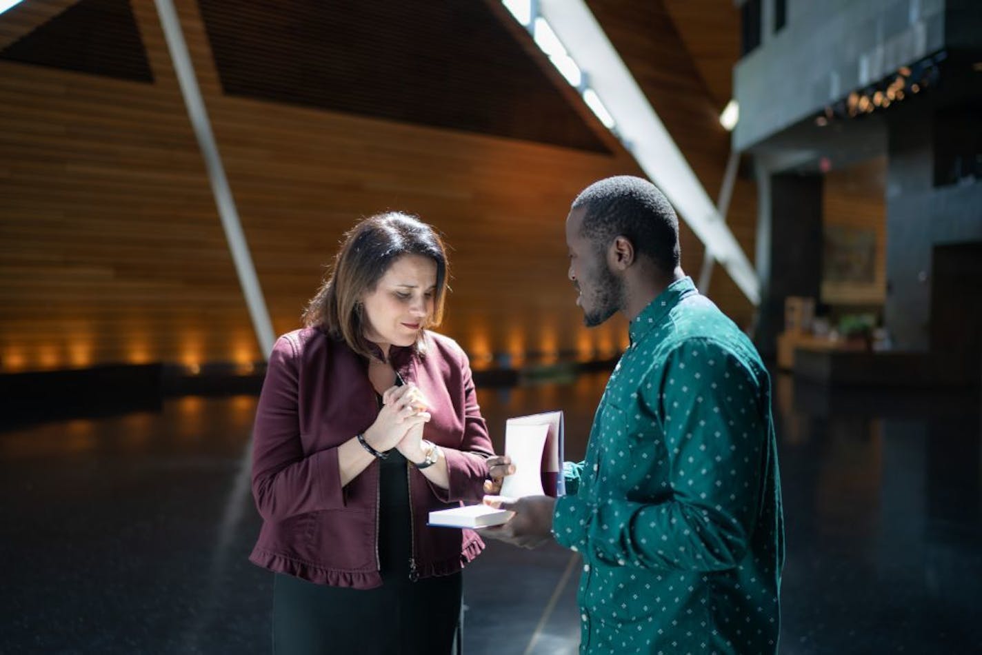 New student Regent Mike Kenyanyu surprised Incoming University of Minnesota President Joan Gabel with a signed copy of civil rights leader Josie Johnson's new memior.