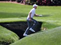 Jordan Spieth runs across the tributary to Rae's Creek to the 13th green during his practice round for the Masters at Augusta National Golf Club.